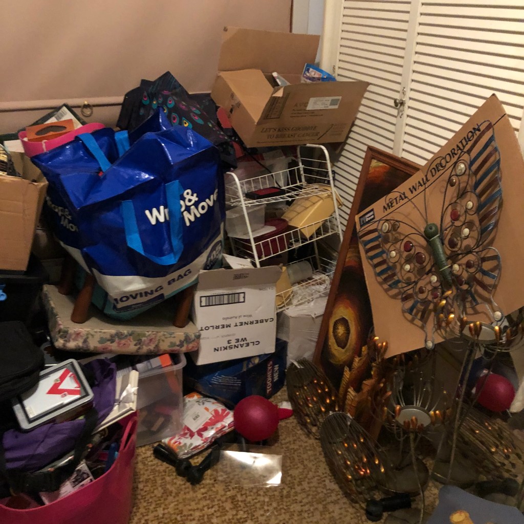 A cluttered storage space with shelves filled with kitchenware, tools, and miscellaneous items.