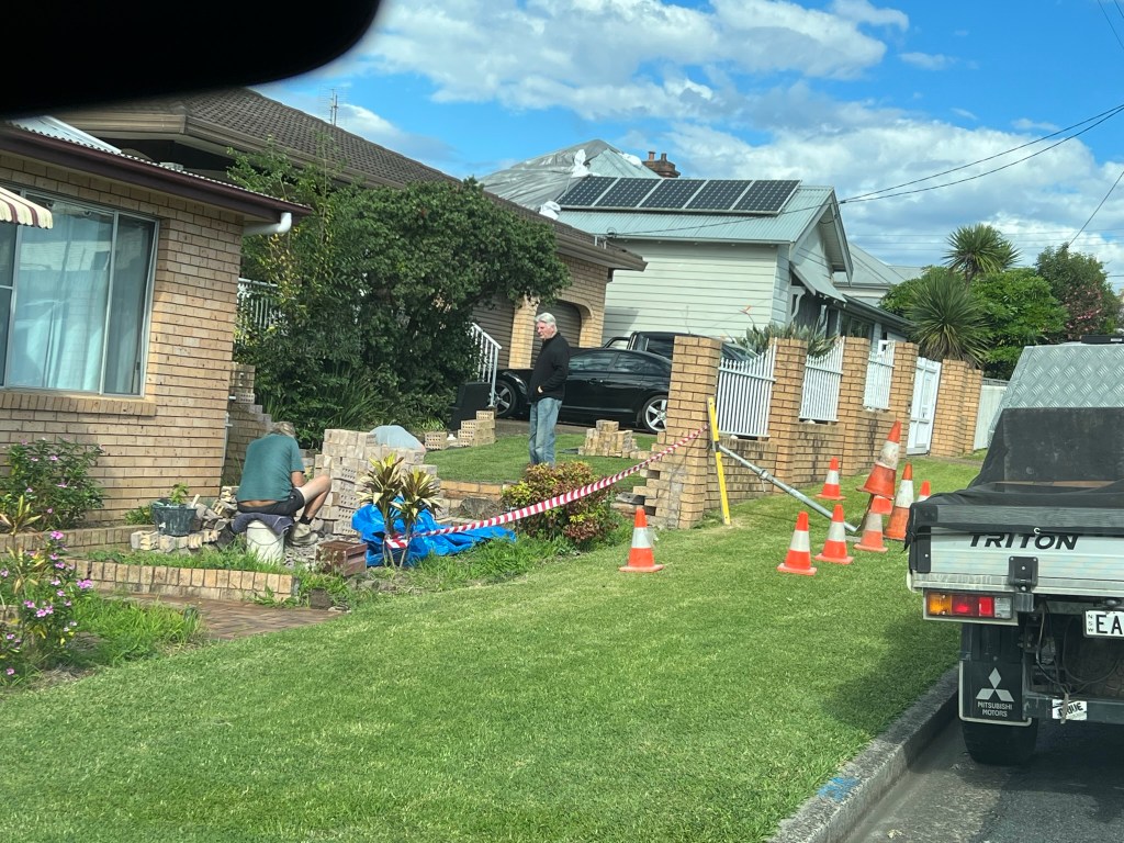 Laying fence brick work outside on a home boundary wall. Apart of our home improvement services.