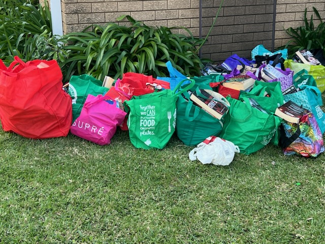 Garbage bags filled with assorted items placed on a grassy area.. Related to our hoarding solutions