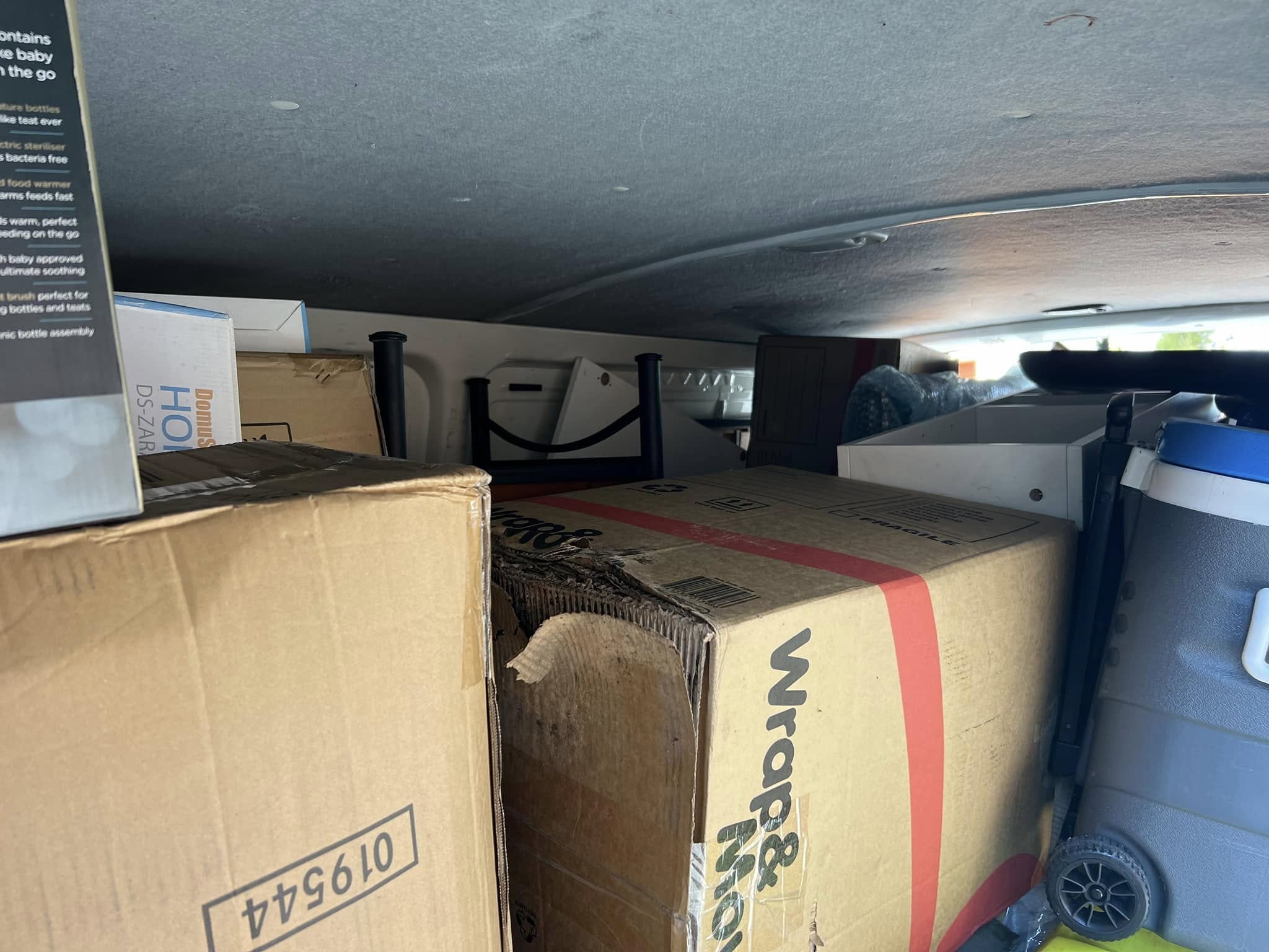 A truck packed with stacked boxes and furniture, possibly for moving or disposal