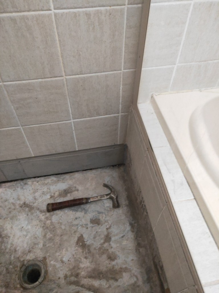 Inside photo of progress work of EPS laying tiles in a shower and bathroom area