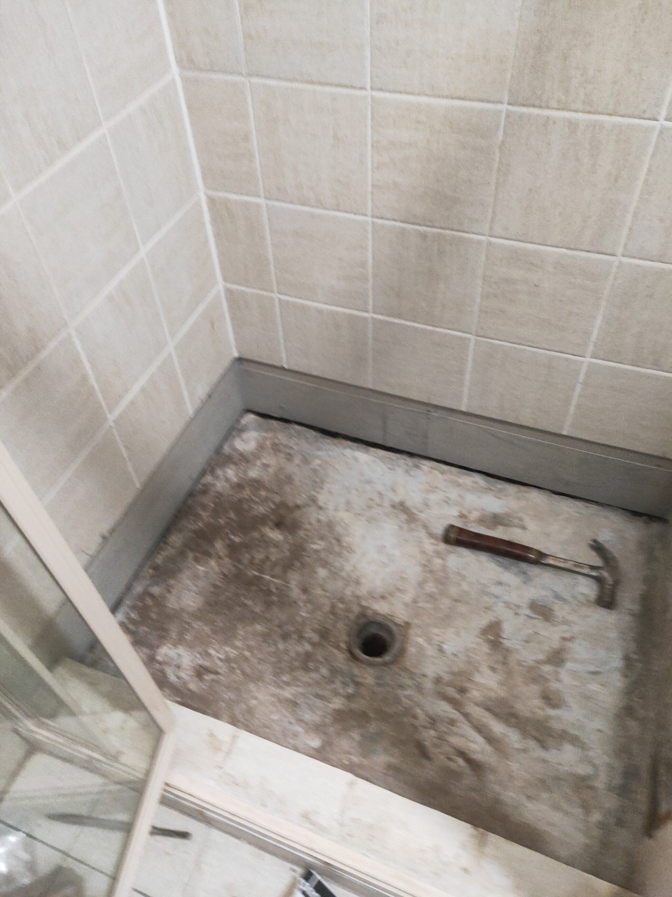 Inside photo of progress work of EPS laying tiles in a shower and bathroom area 