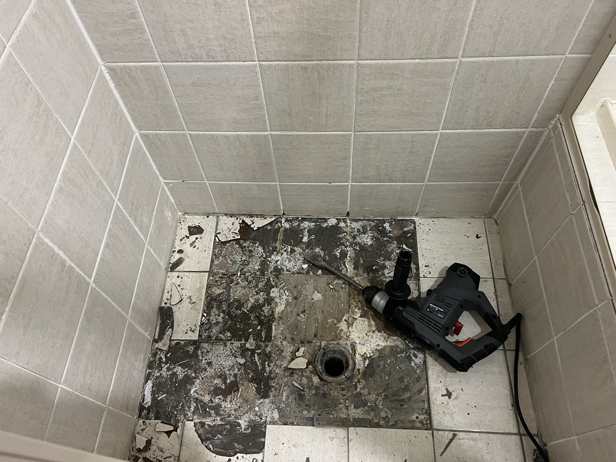 Inside photo of progress work of EPS laying tiles in a shower and bathroom area 