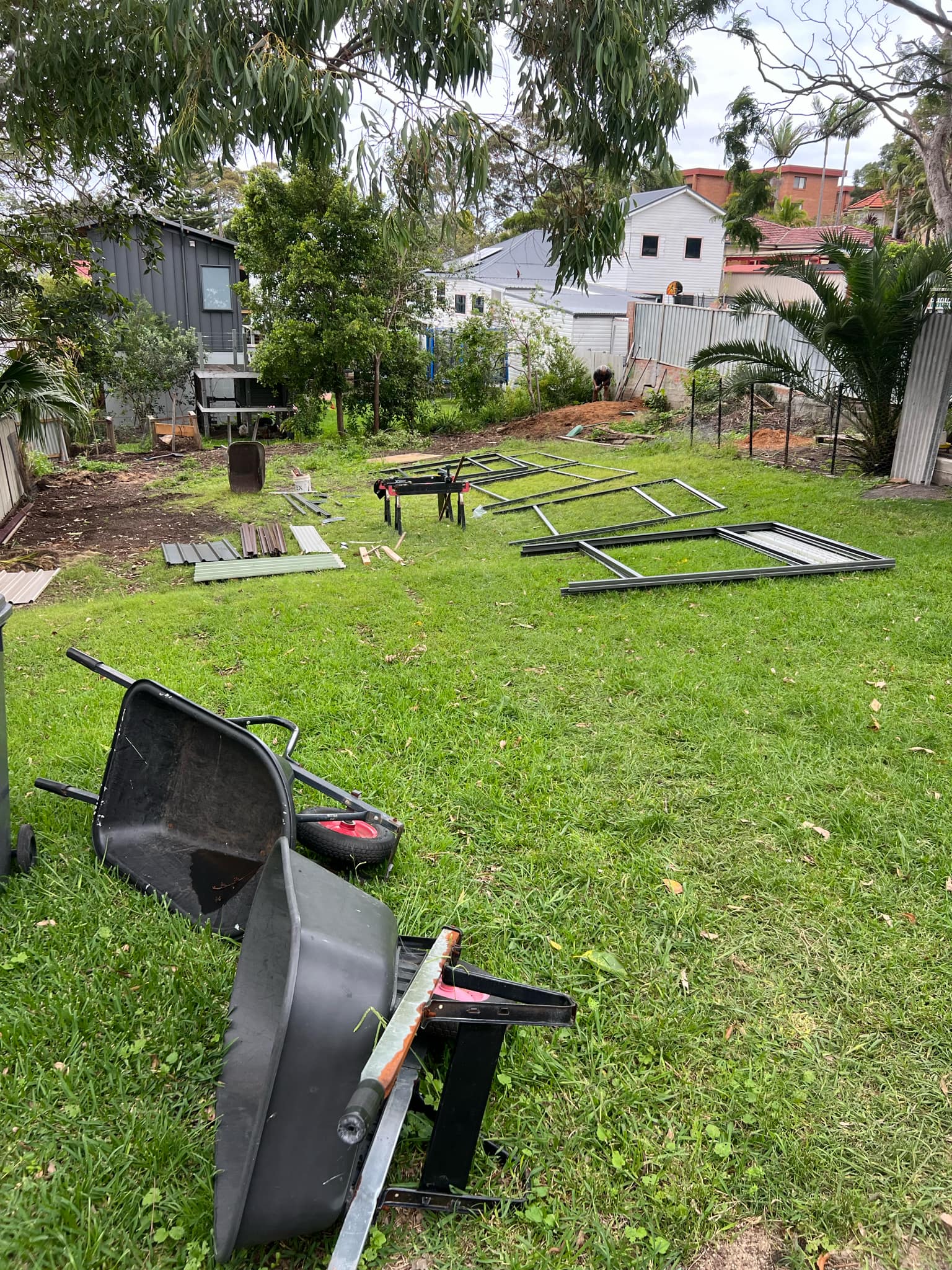 Partially installed wooden fence with surrounding greenery.