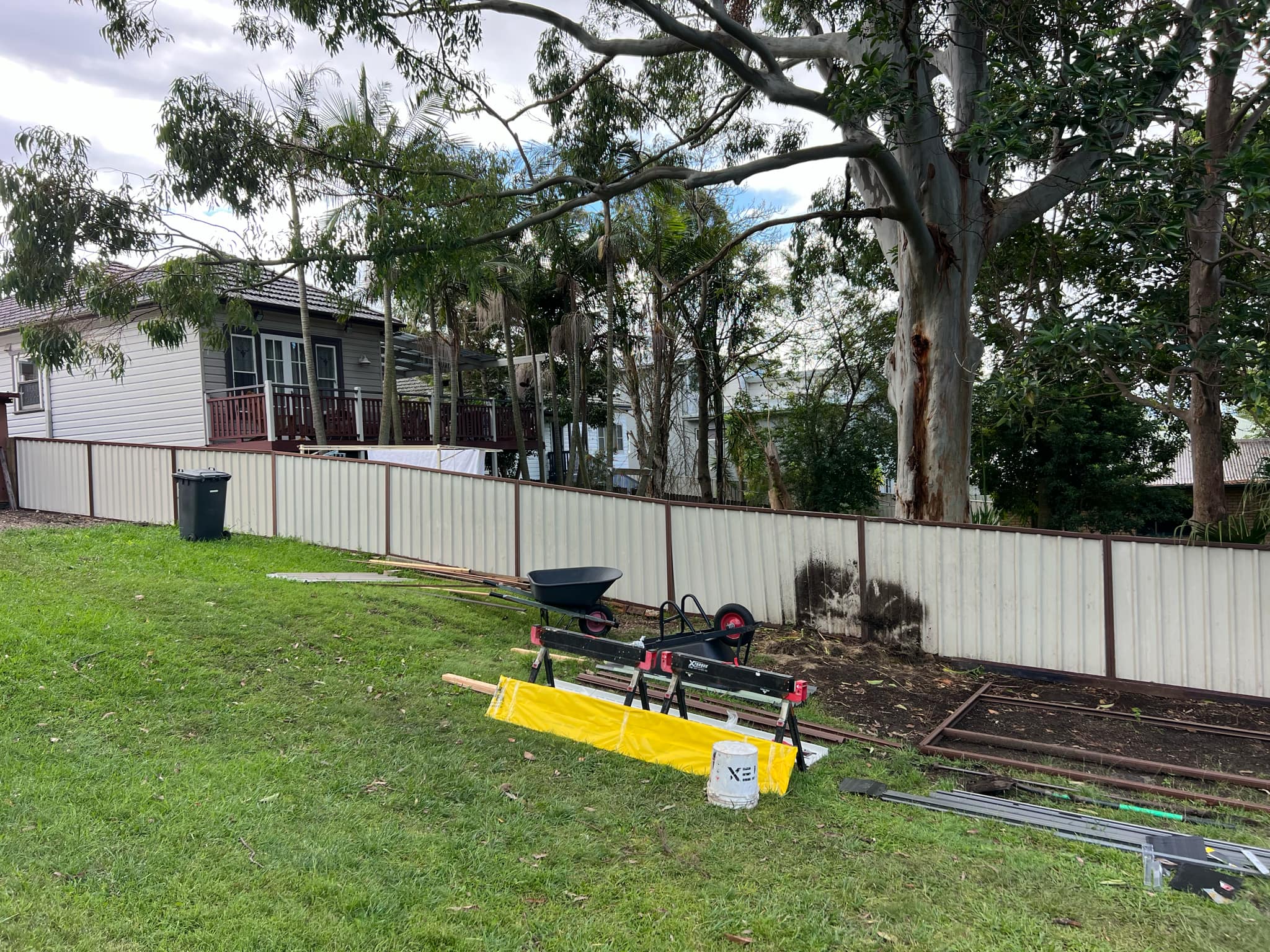 Large cleared area in a backyard, with some construction materials.