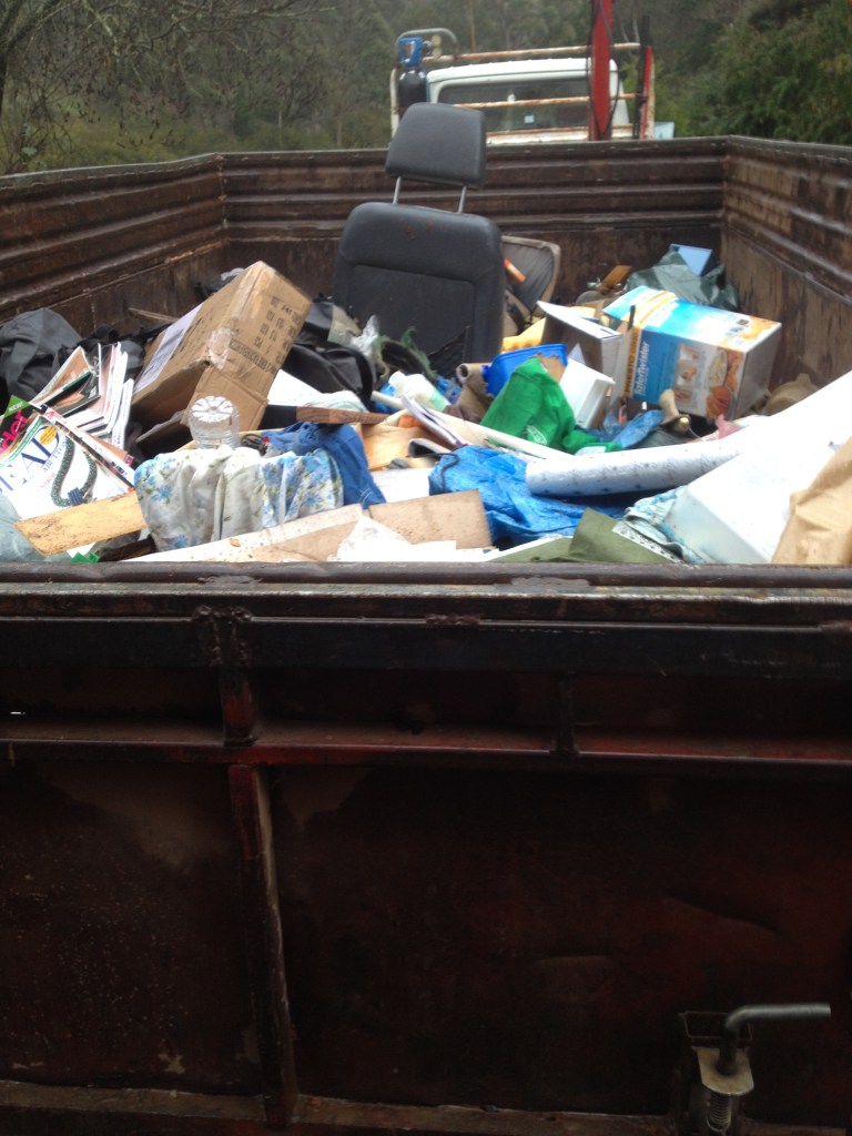 A close-up of a trailer filled with bags and various waste materials.